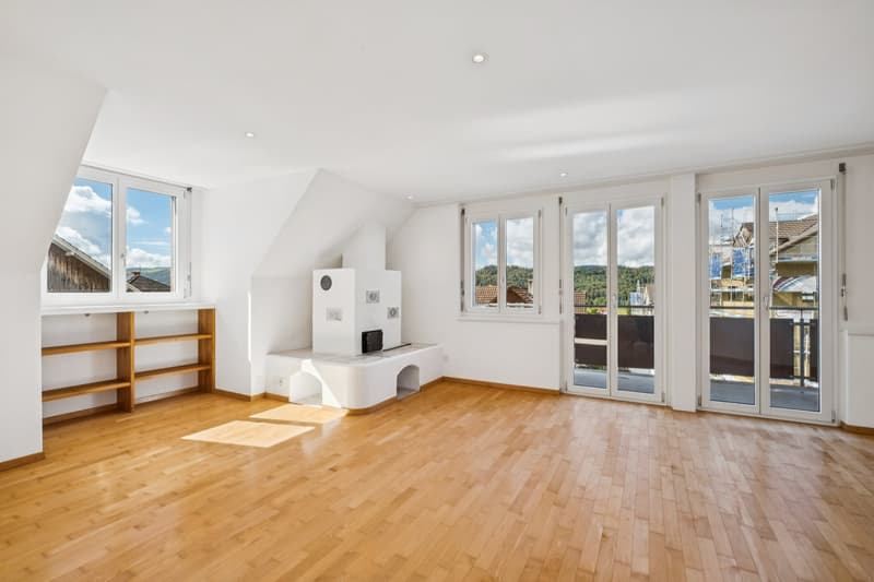 Ein Ort zum Ankommen: Heller Wohnbereich mit Balkon und behaglichem Cheminée