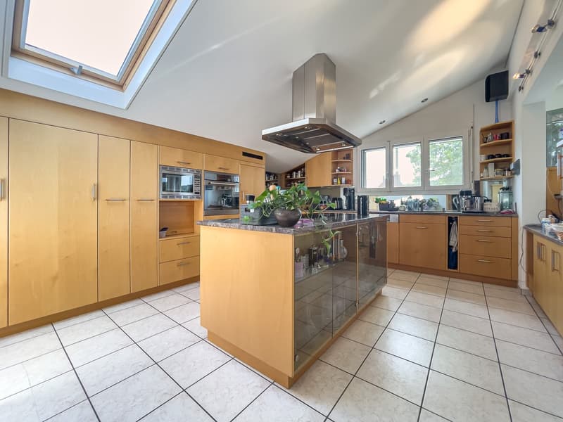 modern kitchen with island, wooden cabinets, granite countertop, stainless steel appliances, skylight, white tile flooring
