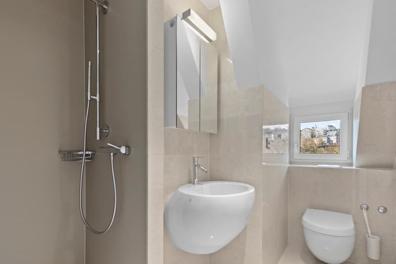 modern bathroom with beige tiles, white sink, white toilet, shower head, mirror, window