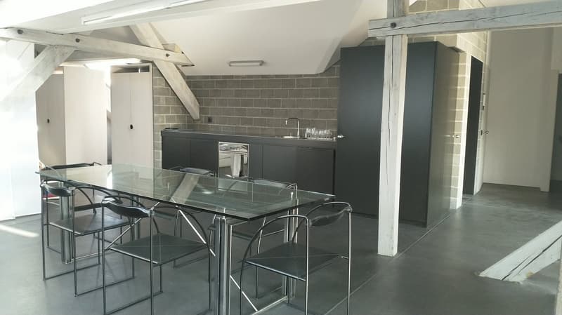 glass table, black chairs, kitchen area with sink and oven