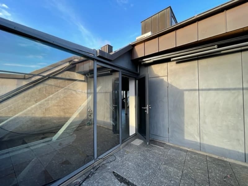 Outdoor area with raised ground floor and balcony, glass walls and doors