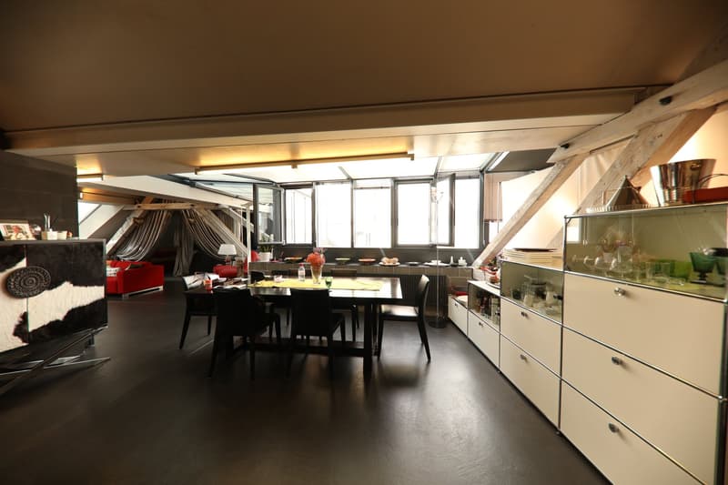 Dining room with glass windows, high ceiling, table and chairs, shelves, cabinets