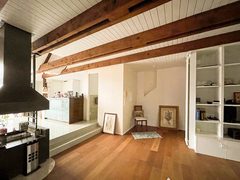 wood floor, wooden beams, fireplace, white walls, staircase, kitchen, chair, shelves, picture frame