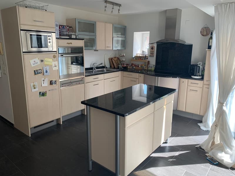 modern kitchen with island, black granite countertop, stainless steel appliances, wooden cabinets, tiled floor