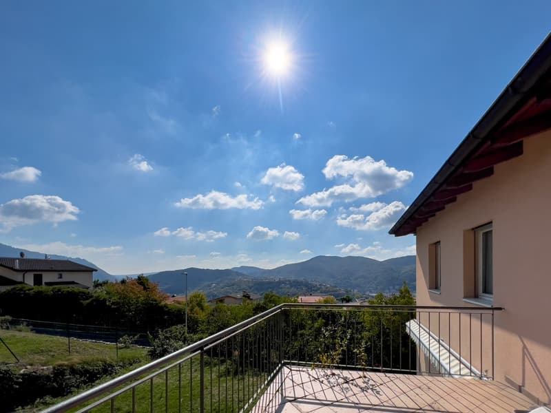 Terrace with metal railing, sunny day, mountains and sky in the background