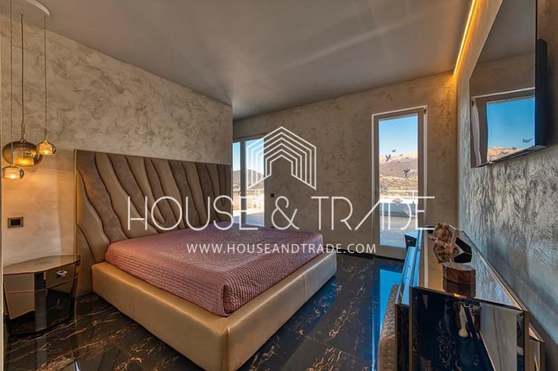 Modern room with a large bed, marble floors, large windows, decorative items, ceiling lamps