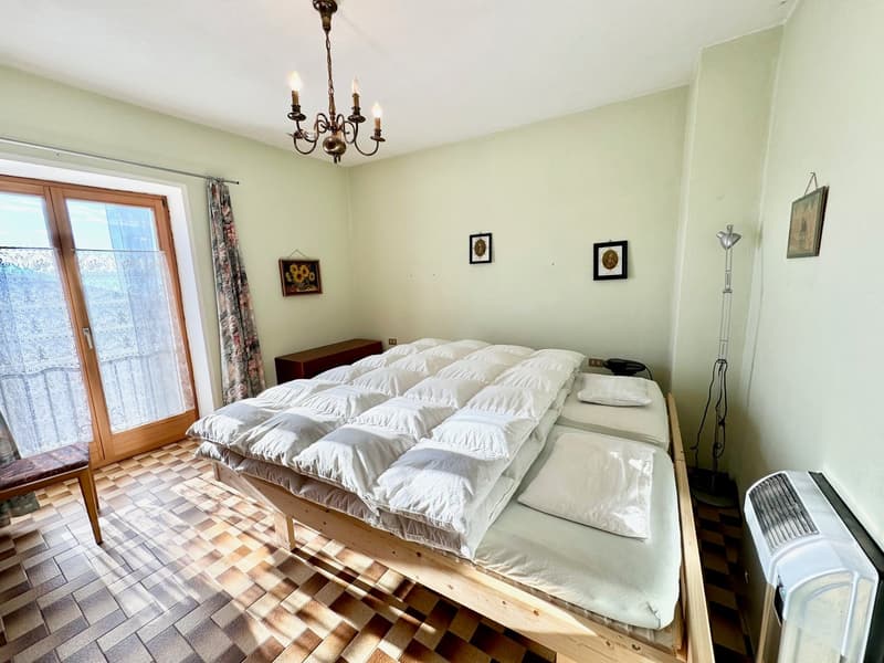 double bed, white duvets, bed headboards, white pillows, wooden cabinet, chandelier, window, wooden chair, wall pictures, standing lamp, radiator