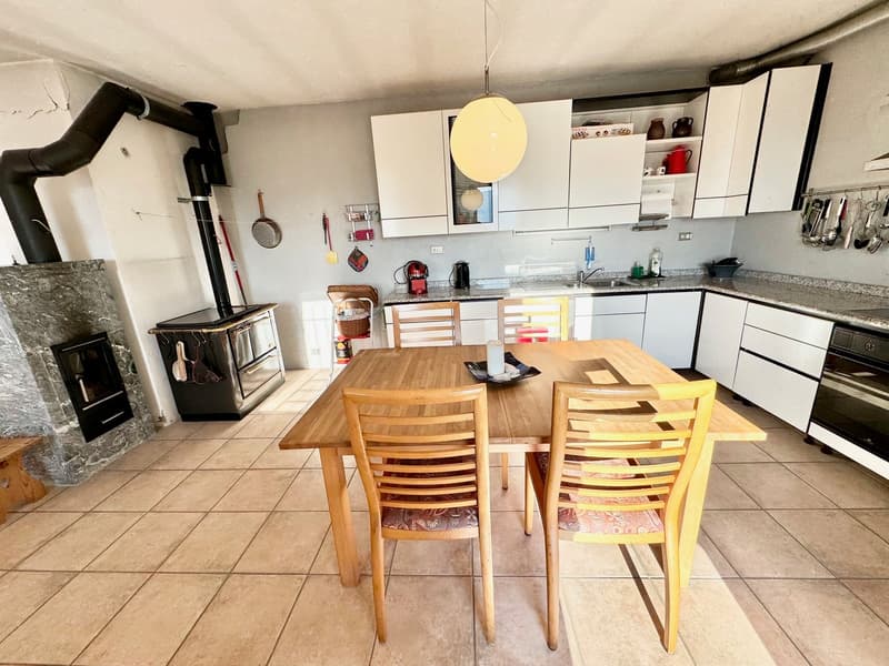 Central island, kitchenware, gas cooker, oven, chairs, dining table, open fireplace, built-in shelves