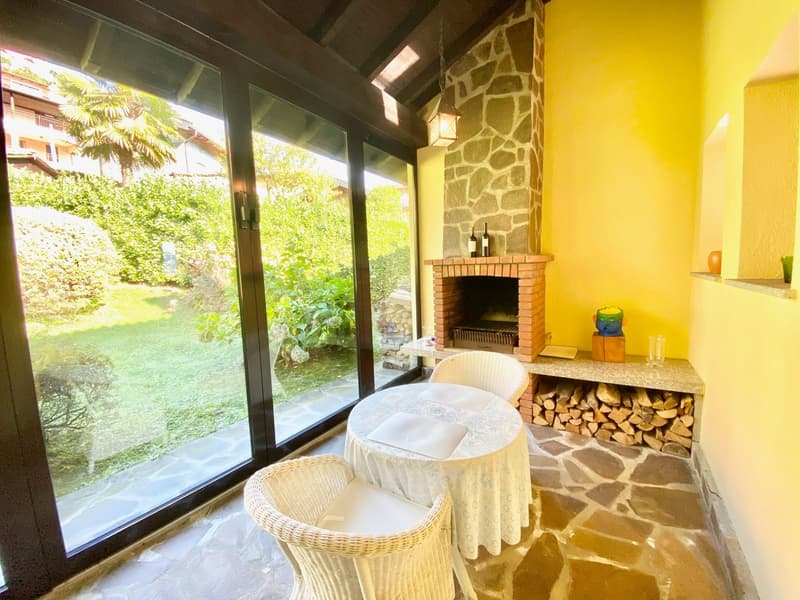 sitting room with fireplace, patio access, stone floor, table with chairs, large glass windows with view