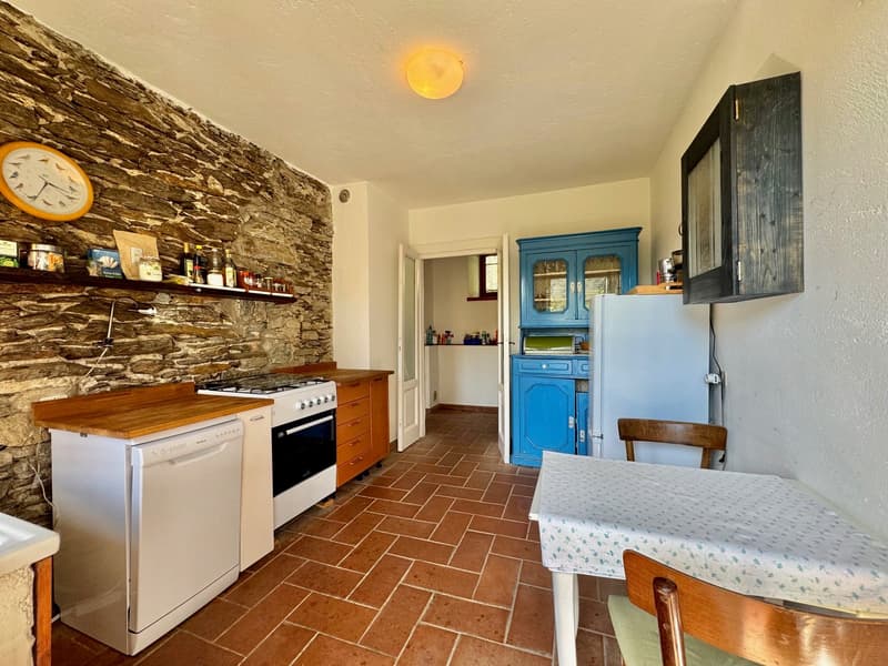 kitchen with a table and chairs, dishwasher, brick wall, wooden ceiling, stove, refrigerator, clock, cabinets, open door