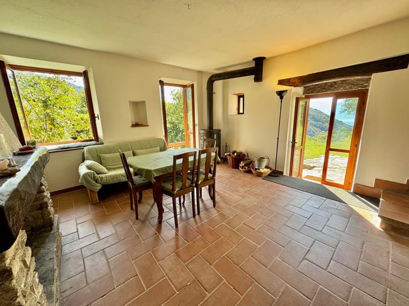 dining area with table, chairs, sofa, fireplace, large windows, terracotta tiles