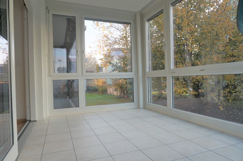 spacious balcony with sliding glass doors, large windows, tiled floor, garden view