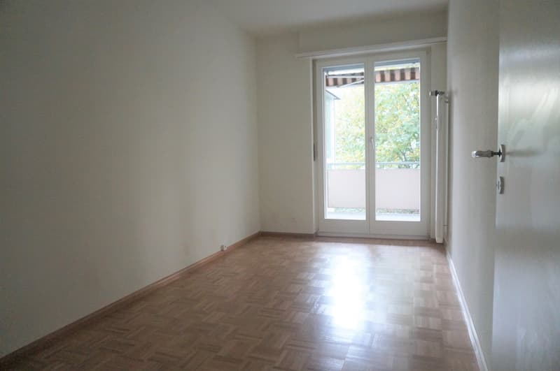 empty room, wooden floor, white walls, sliding doors with glass, balcony with awning