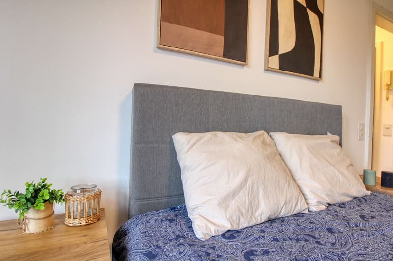 Bedroom with bed, nightstands, and wall art.