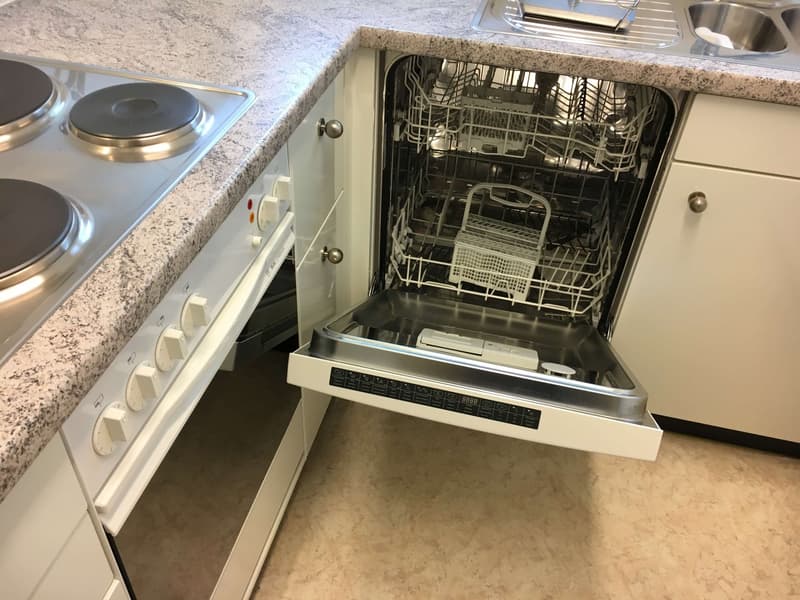 Open dishwasher, modern kitchen setup with a marble countertop