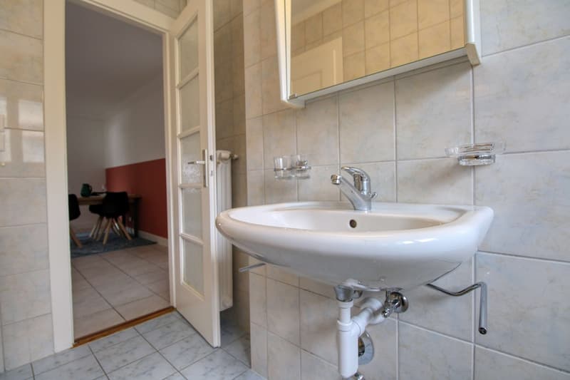 Bathroom with sink, mirror, and radiator