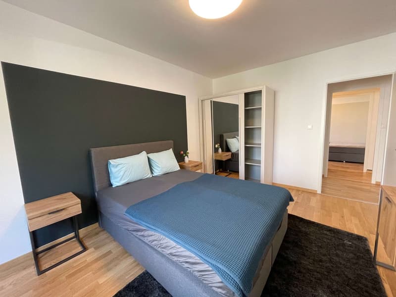 Bedroom with bed, nightstands, wardrobe, carpet, and wooden floor