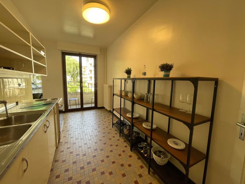 kitchen with sink, shelves, balcony, sliding glass door, radiator, plants, wine glasses