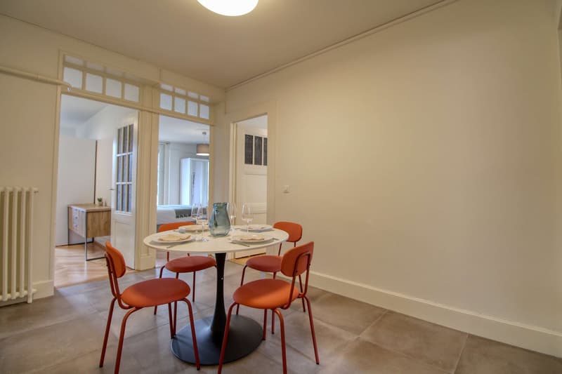 Dining room with a round table, four chairs, and a white wall