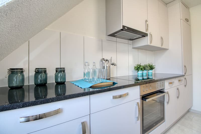 modern white kitchen, granite countertop, kitchen appliances, blue mats, stainless steel kitchen utensils, white cabinetry, overhead cabinets