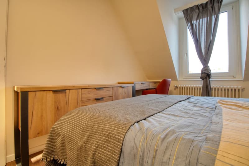 double bed, wooden wardrobe, desk, chair, window with curtain, radiator