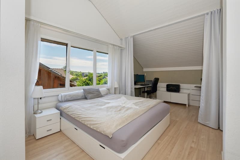 Bedroom with double bed, desk with chair, lamp, storage units, and large window with view