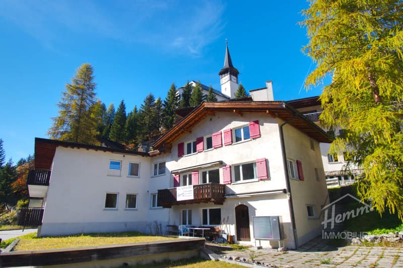 2 story house, white walls, red shutters, brown roof, balcony, trees, mountain view
