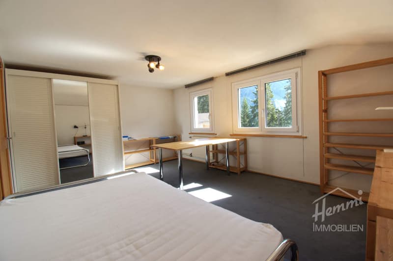 bedroom with bed, desk, shelves, wardrobe, windows