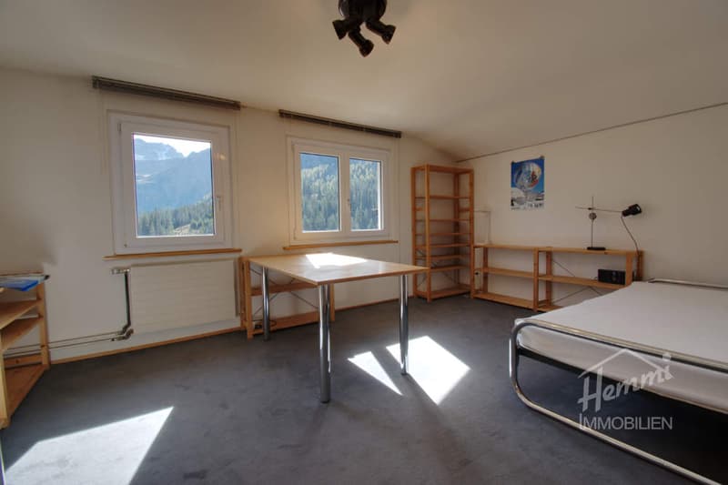empty room, desk, bed, shelves, windows with mountain view