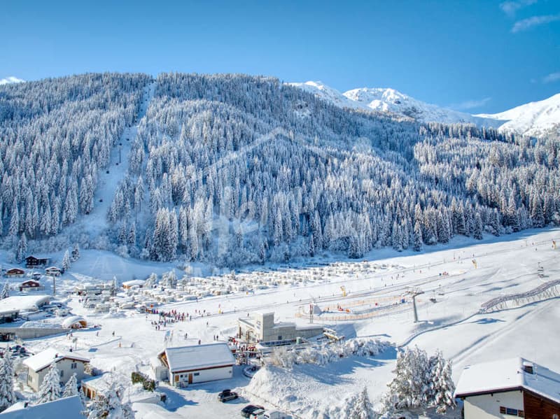 Snowy mountains, ski slopes, ski lift, buildings, people skiing, cars parked