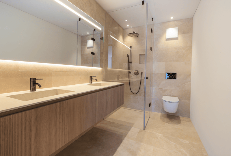 modern bathroom with double sink, large mirror, glass shower enclosure, walk-in shower, toilet