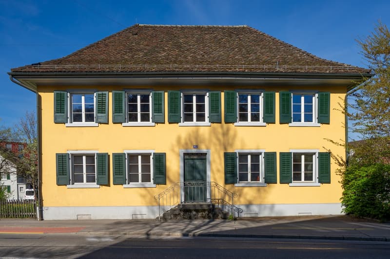 2 story yellow house, brown roof, green shutters, white trim, front door, steps leading up