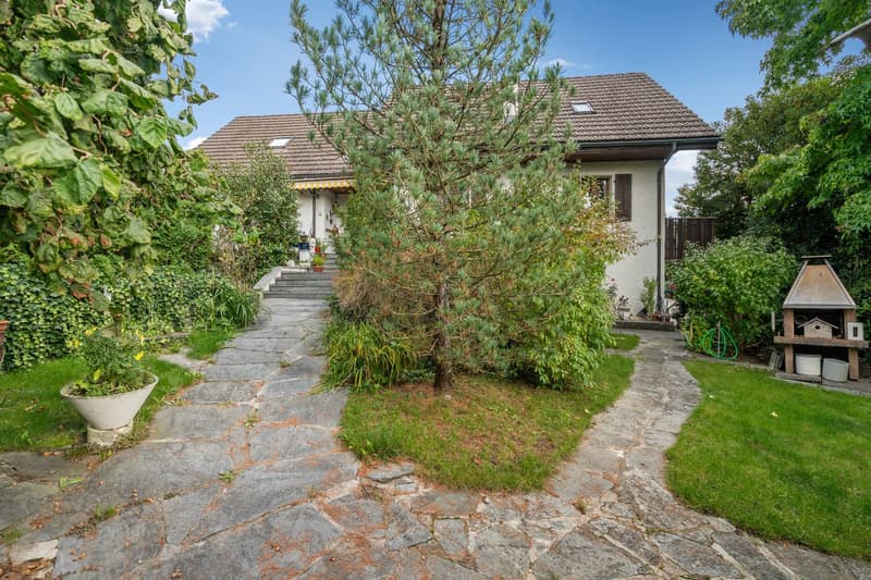 Single family house with well-kept garden and a stone path leading to the entrance