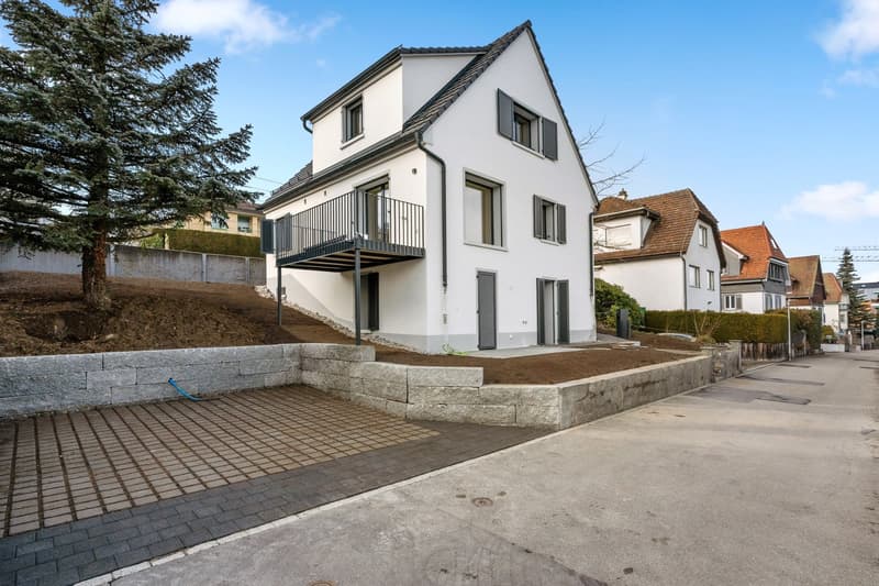 2 story white house, black windows, balcony, driveway, trees