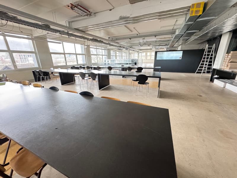 empty conference room with long desks and large windows
