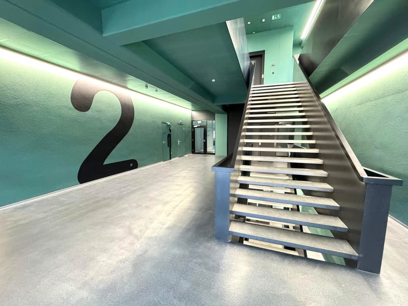 empty hallway, metal railings, steps leading up, green walls, number 2 on the wall