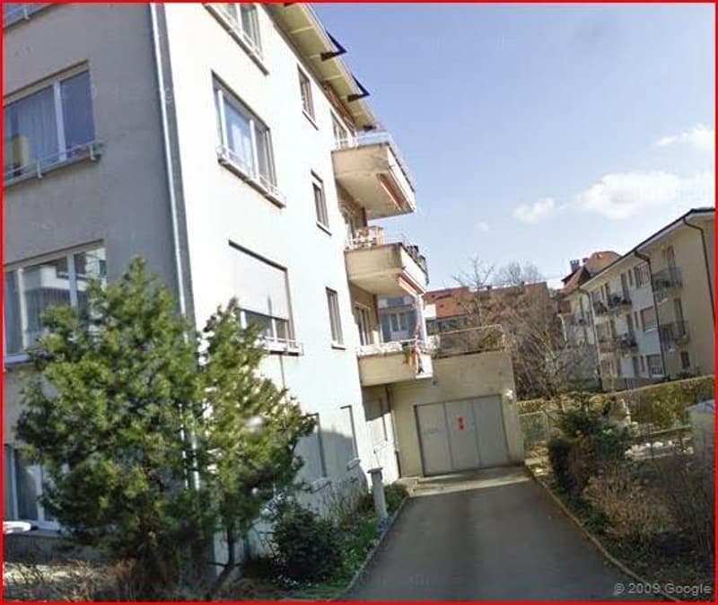multi-story building with multiple balconies and garage entrance