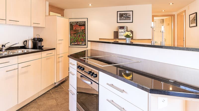 modern kitchen with granite countertops, stainless steel appliances, wooden cabinets, and a gas stove