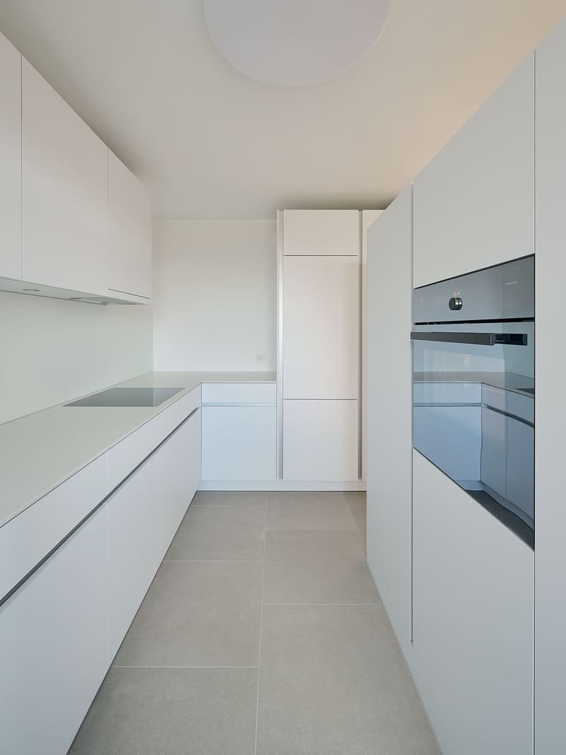 White kitchen, tiled floor, integrated oven, modern cabinets
