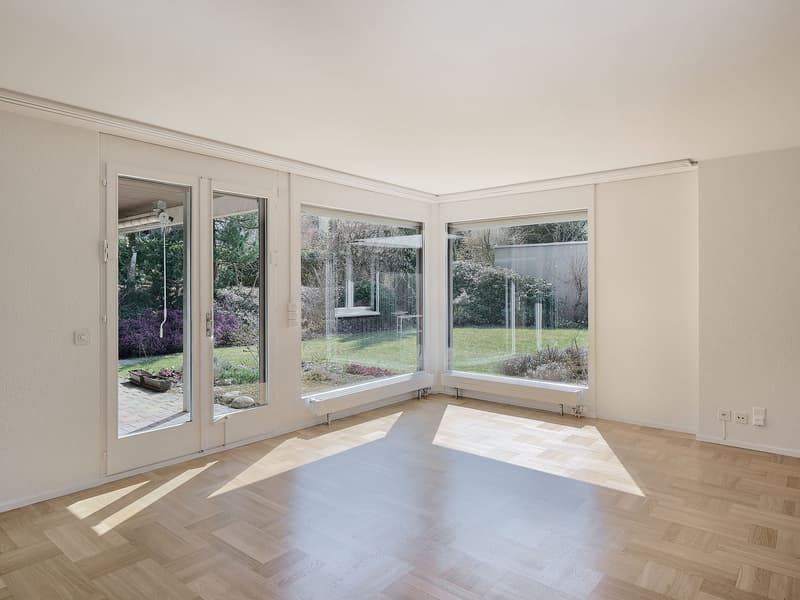 Empty room, large windows, wooden floor, bright