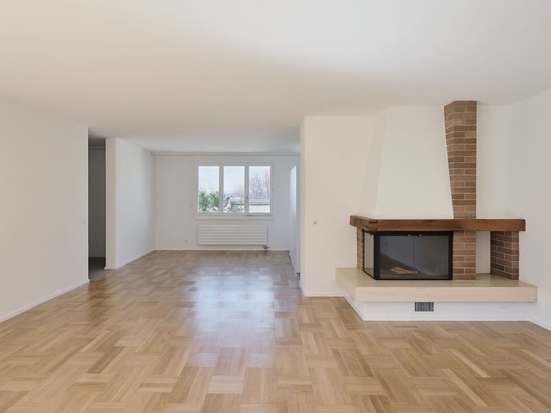 Empty room with parquet floors, fireplace, windows, and radiator