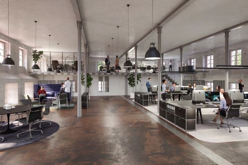Industrial style office with multiple workstations, communal areas, mezzanine, and open layout.