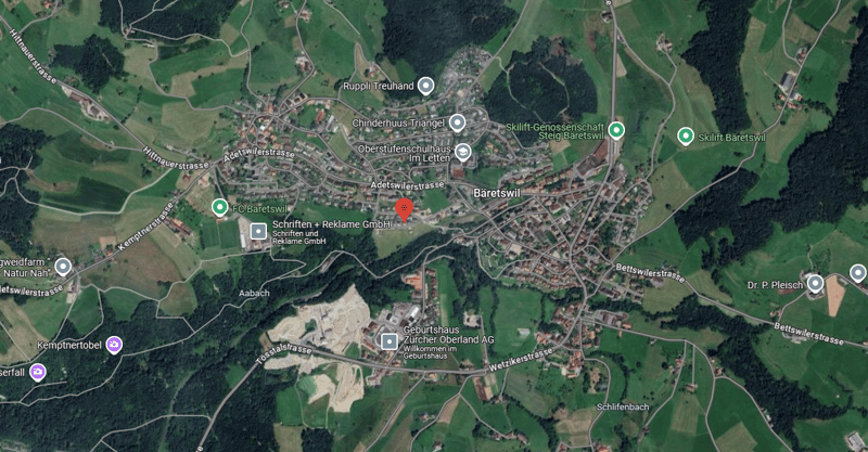 The image shows a satellite map of a rural area with a town called Baretswil. The map includes various landmarks and businesses such as Schriften + Reklame GmbH, FC Baretswil, Skilift Baretswil, and Geburtshaus Zurcher Oberland AG. The map also shows road