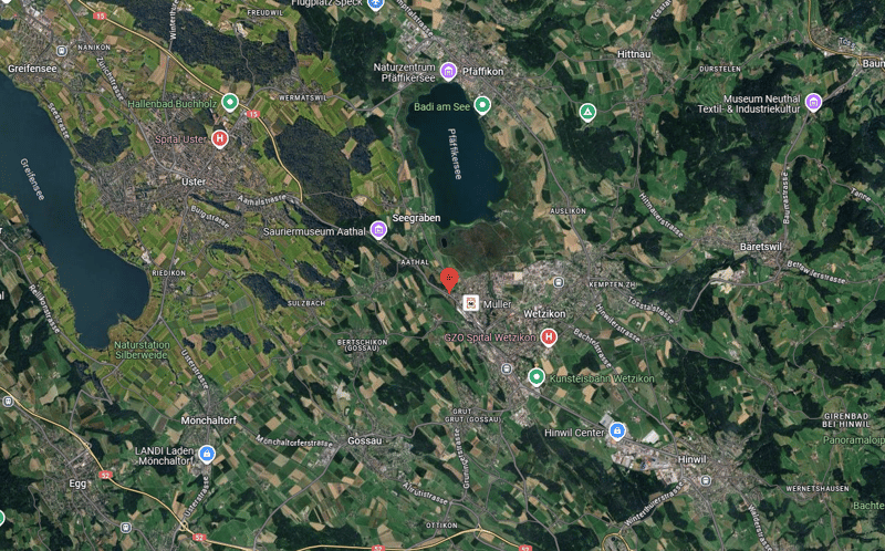 Map showing a lake and several towns in the region. The map contains green fields, blue water, and green icons with labels such as 'Hallenbad Buchholz' and 'GZO Spital Wetzikon'.