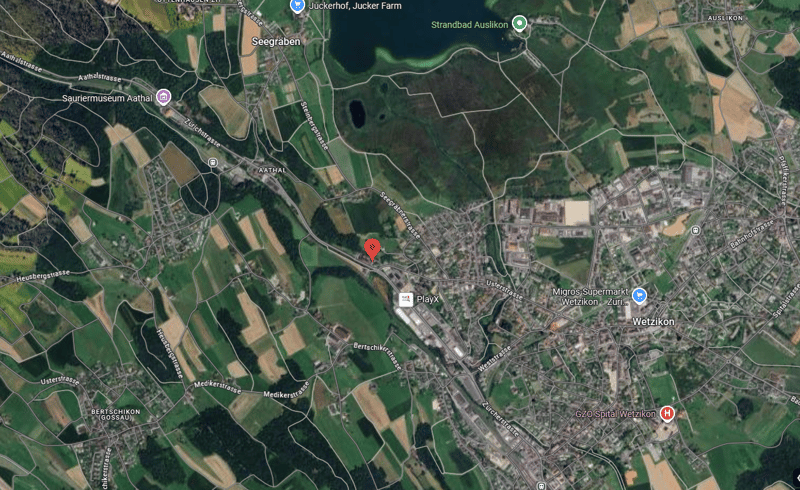 Aerial view of the town, showing the layout of roads, buildings, and surrounding areas. The map highlights the PlayX location and other notable landmarks such as Wetzikon City Hall, Migros Supermarket, and the hospital.