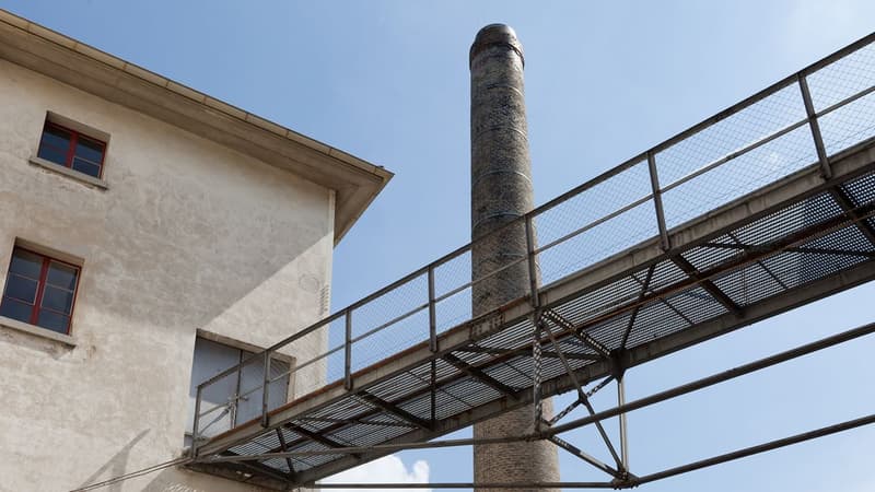 industrial style building, concrete construction, narrow chimney, metal bridge, windows with red frames