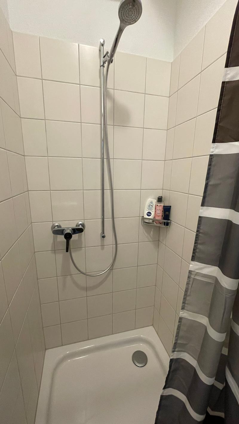 shower area with shower head, shower hose, shower shelf, shower curtain, shower drain