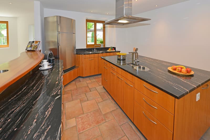 modern kitchen, granite countertops, wooden cabinets, stainless steel appliances, double sink, gas stove, refrigerator, dishwasher, coffee machine, plates, cups, fruits