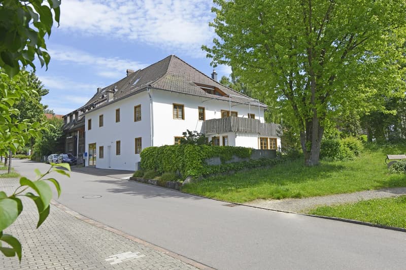 2 story house, white exterior, brown roof, balcony, windows with yellow frames, driveway, cars parked