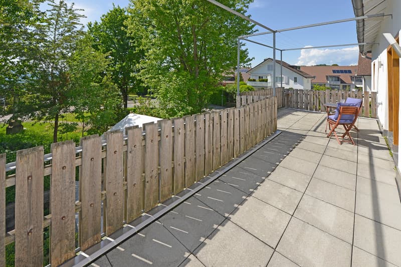 Wooden fence, tiled floor, wooden chairs, table, metal railing